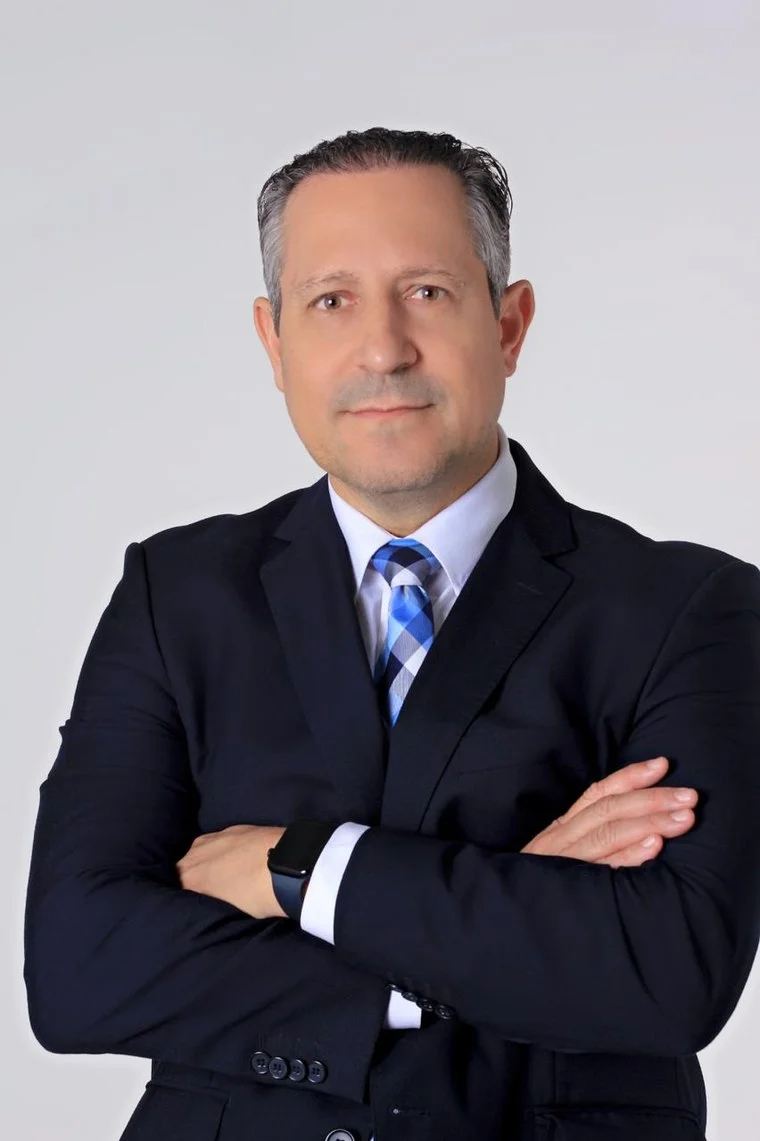 Ricardo Alberto Escher, advogado e palestrante corporativo, em pose de retrato profissional de terno escuro